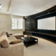 a media room with a curved TV wall with brown sofas