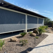 Side view of a patio area with lowered Progressive Screens beside a garden path.